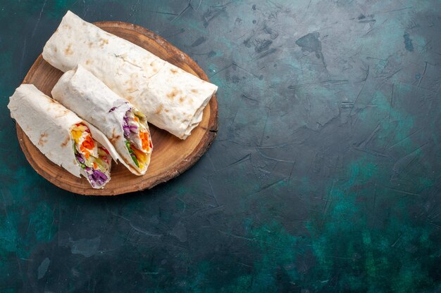 Bovenaanzicht vlees sandwich een sandwich gemaakt van vlees gegrild aan het spit met groenten op donkerblauw bureau sandwich hamburger eten maaltijd lunch