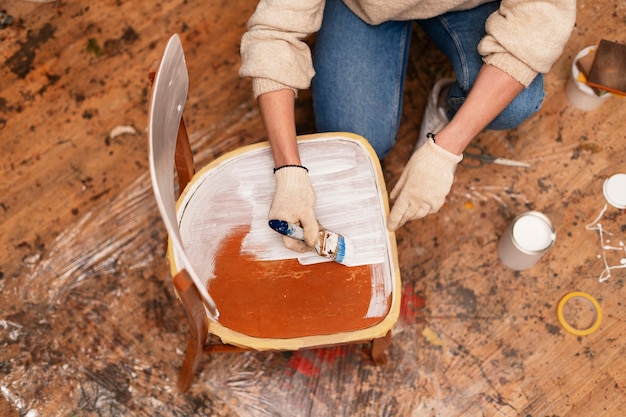Gratis foto bovenaanzicht vrouw die houten meubels herstelt