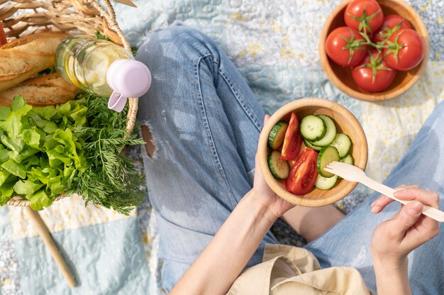 Bovenaanzicht vrouw met slakom bij picknick