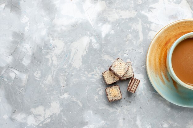 Bovenaanzicht wafels en koffie op het witte bureau zoete melk drinken kleurenfoto