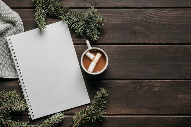 Bovenaanzicht warme chocolademelk met lege notebook en kopie-ruimte