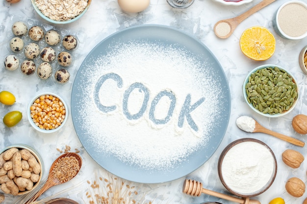 Bovenaanzicht witte bloem binnen plaat met noten gelei zaden en eieren op een lichte taart noten deeg eten cake biscuit kok foto kleur bakken