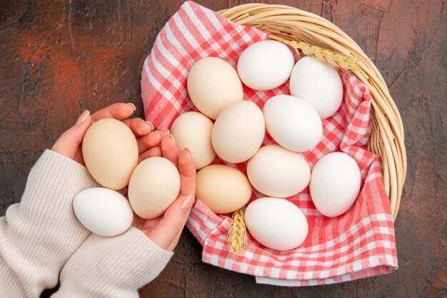 Bovenaanzicht witte kippeneieren in mand met handdoek op donkere tafel eten rauwe boerderij ontbijt kleurenfoto maaltijd