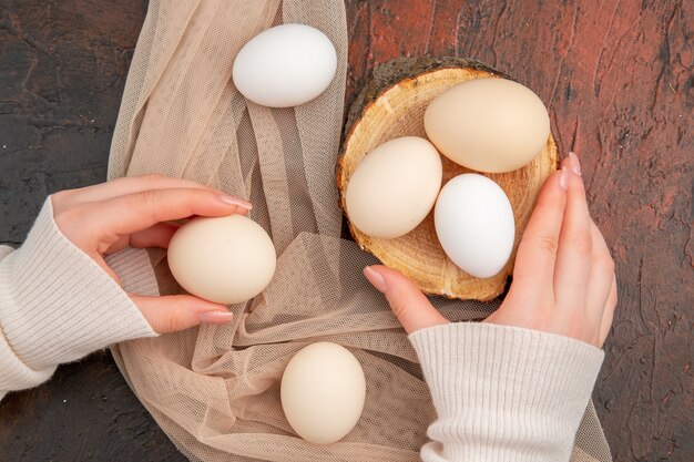 Bovenaanzicht witte kippeneieren op de donkere tafel