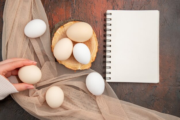 Bovenaanzicht witte kippeneieren op de donkere tafel