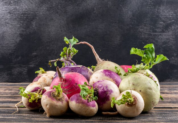 Gratis foto bovenaanzicht witte radijs met wat blad op donkere en houten tafel