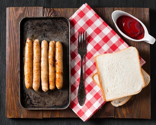 Bovenaanzicht worstjes op dienblad met brood