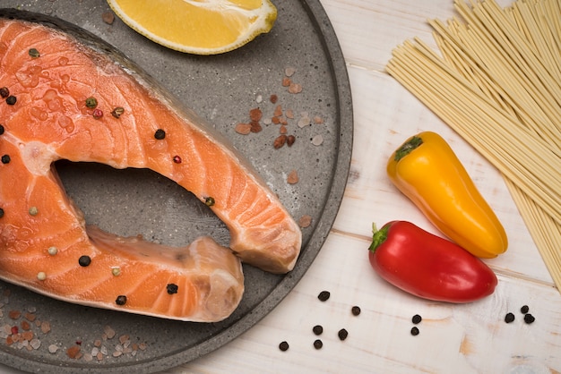 Bovenaanzicht zalm steak op dienblad met paprika