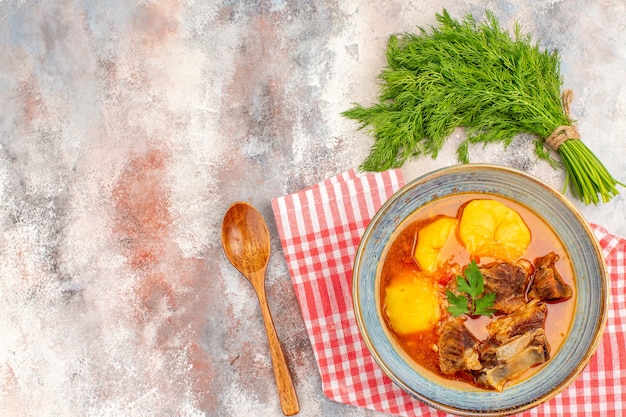 Bovenaanzicht zelfgemaakte bozbash soep keukenhanddoek een stelletje dille lepel op naakte achtergrond vrije ruimte