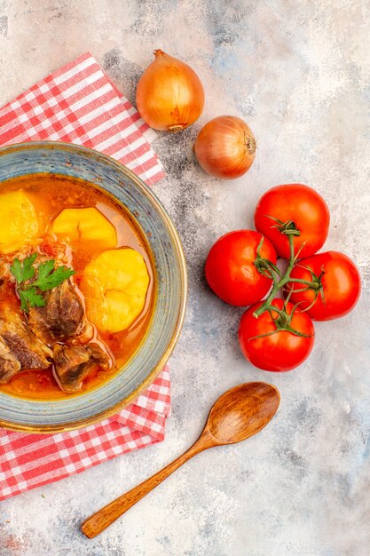 Bovenaanzicht zelfgemaakte bozbash soep keukenhanddoek uien tomaten op naakt oppervlak