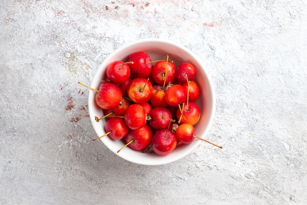 Gratis foto bovenaanzicht zoete kersen vers en zacht fruit op wit oppervlak kersen fruit versheid sappig zacht