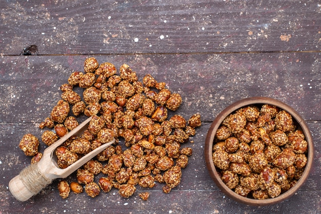 Bovenaanzicht zoete kleverige noten met honing op de houten foto van de zoete snack van de bureaunoot