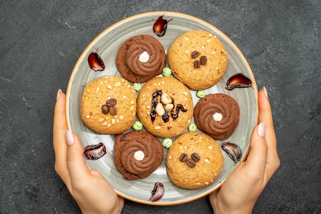 Bovenaanzicht zoete koekjes in plaat op donkergrijze achtergrond suikerkoekje zoete koektaart thee