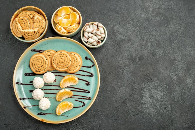 Bovenaanzicht zoete koekjes met kokos snoepjes op de grijze achtergrond