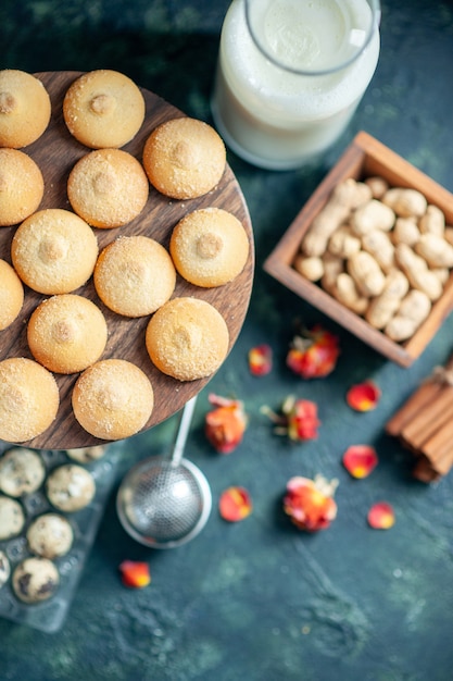 Bovenaanzicht zoete koekjes met melk op donkerblauwe achtergrond taart biscuit thee dessert cookie suiker cake