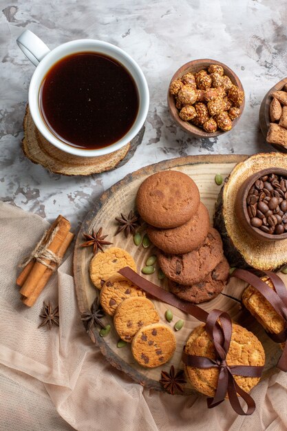 Bovenaanzicht zoete koekjes met noten en kopje koffie op de lichttafel