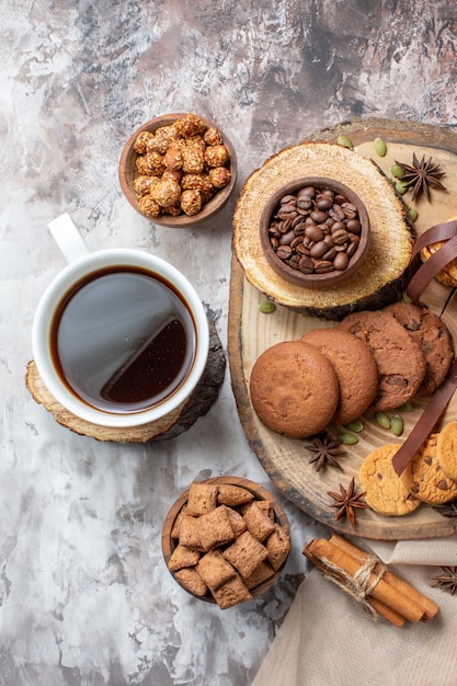 Bovenaanzicht zoete koekjes met noten en kopje koffie op licht bureau