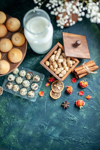 Bovenaanzicht zoete lekkere koekjes met melk en noten op donkerblauwe achtergrond taart biscuit thee taart foto dessert cookie suiker