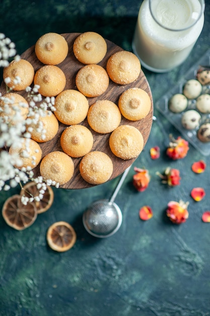 Bovenaanzicht zoete lekkere koekjes met melk op donkerblauwe achtergrond taart biscuit thee dessert cookie suiker cake