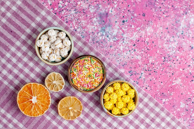 Bovenaanzicht zoete snoepjes kleurrijke confitures op roze bureau