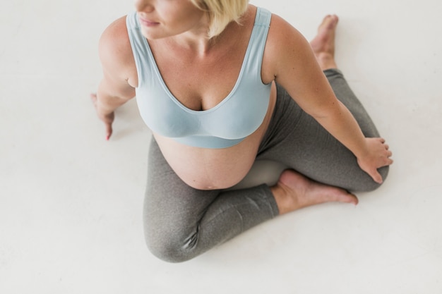 Bovenaanzicht zwangere vrouw zittend op de vloer