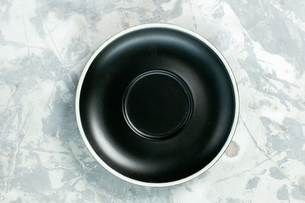 Gratis foto bovenaanzicht zwarte plaat lege ronde gevormd op een witte oppervlak plaat glas voedselkleur