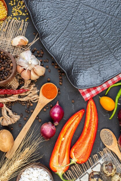 Bovenaanzicht zwarte schotel rijst kwarteleitjes houten lepel knoflook kruiden op tafel