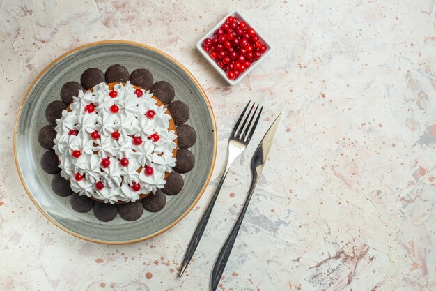 Bovenaanzichtcake met banketbakkersroom en chocoladevork en dinermesbessen in kom