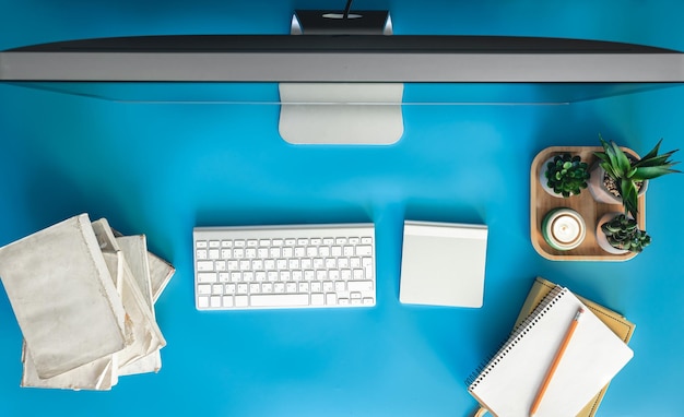 Gratis foto bovenbeeld computer en boeken op een blauwe tafel bureaublad