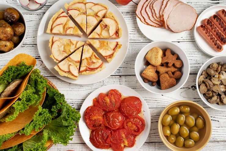 Gratis Foto bovenbeeld op tafel vol met verschillende soorten voedsel