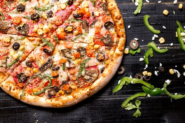 Bovenbeeld van de helft van de pepperoni pizza met sesam strooitjes