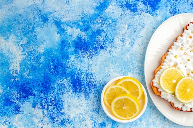Bovenste halve weergave kerstboomcake op plaat citroenschijfjes op blauwe tafel