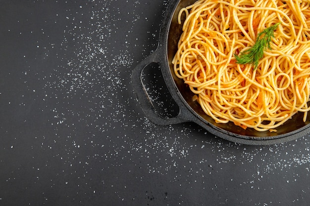 Bovenste helft spaghetti-pan op donker oppervlak met vrije ruimte