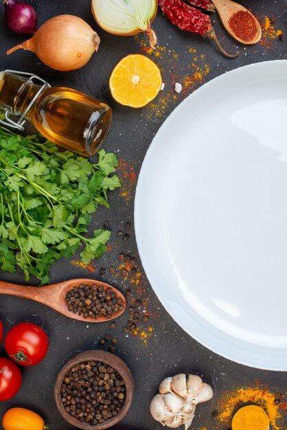 Bovenste helft witte ronde plaat zwarte peper in kleine kom knoflooktomaten