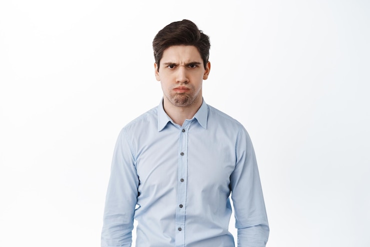 Gratis Foto boze en ontevreden kantoormedewerker fronst en ziet er gek uit, gehinderd of beledigd, woedend, kokend van woede, staande op een witte achtergrond