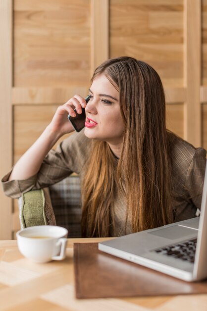 Boze jonge vrouw met behulp van haar mobiele telefoon