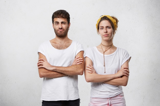 Boze koppige man en vrouw die in gesloten houdingen staan, armen over elkaar houden, onenigheid in relaties onder ogen zien terwijl ze conflicten of ruzie hebben