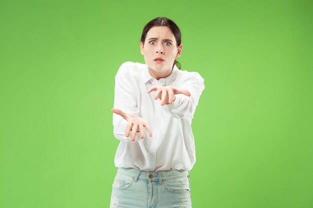 Boze vrouw die camera bekijkt. Agressieve zakenvrouw staande geïsoleerd op trendy groene ruimte