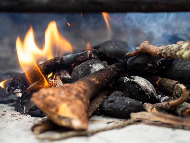 Brandhout in kampvuurplaats met rook