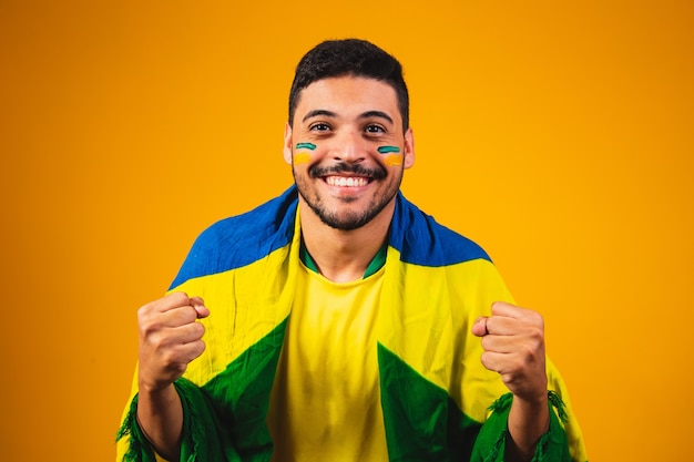 Braziliaanse fan juichen in de menigte op gele achtergrond.