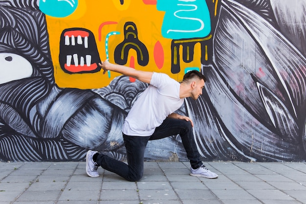 Breakdancer die op geschilderde muurachtergrond danst