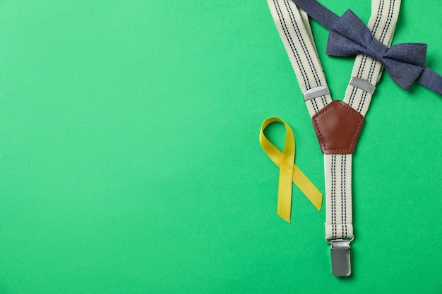 Bretels, stropdas boog en kanker bewustzijn lint op groene achtergrond