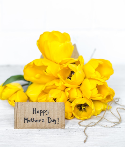 briefkaart Moederdag en gele tulpen op houten