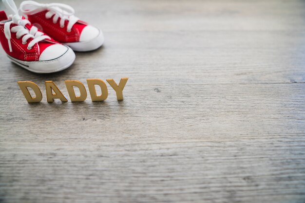 Brieven en rode schoenen op houten oppervlak voor vaderdag