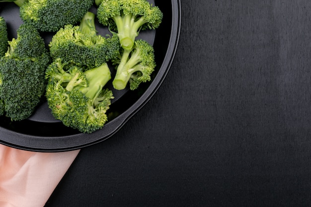 Broccoli in zwarte kom op zwarte oppervlakte hoogste mening met exemplaarruimte