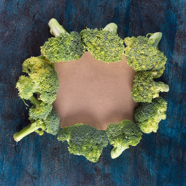 Gratis foto broccoli met blanco papier op tafel