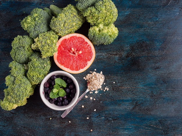 Gratis foto broccoli met bosbessen en grapefruit op tafel