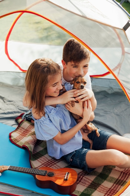 Broer en zus houden van hun huisdier in tent