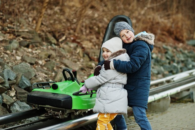 Broer met zus op elektrische slee op rails