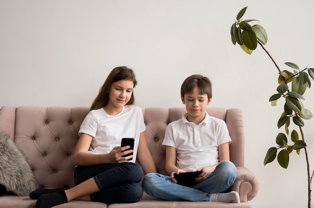 Broers en zussen met behulp van mobiel en tafel